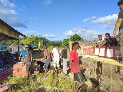 Semangat Gotong Royong Satgas TMMD Kodim Jayapura Bersama Pemuda Turunkan Keramik