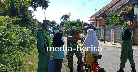 Wujud Kepedulian, Babinsa Koramil Tegal Timur Bersama Linmas Bagikan Masker Gratis